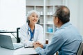 Asian Senior Doctor and patient discussing something while sitting at the table . Medicine and health care concept Royalty Free Stock Photo