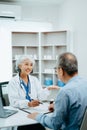 Asian Senior Doctor and patient discussing something while sitting at the table . Medicine and health care concept Royalty Free Stock Photo