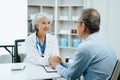 Asian Senior Doctor and patient discussing something while sitting at the table . Medicine and health care concept Royalty Free Stock Photo