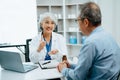 Asian Senior Doctor and patient discussing something while sitting at the table . Medicine and health care concept Royalty Free Stock Photo