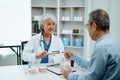 Asian Senior Doctor and patient discussing something while sitting at the table . Medicine and health care concept Royalty Free Stock Photo