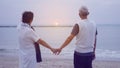 Asian senior elder couple holding hands looking sunset sea ocean together happy retirement life Royalty Free Stock Photo