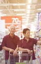 Asian senior elder couple shopping together in supermarket with cart Royalty Free Stock Photo