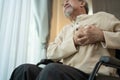 Asian Senior Elderly disabled man on wheelchair with chest pain suffer from heart attack. Older male has difficulty breath Royalty Free Stock Photo