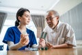 Asian Senior elderly male patient consult with physician nurse at nursing home care. Caregiver therapist pharmacist girl hold medi