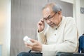 Asian Senior elderly male patient sit on wheelchair at nursing home care. Mature older disabled man looking to medicine pill bottl Royalty Free Stock Photo