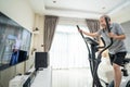 Asian Senior Elderly man workout cardio on cycling exercise bike machine at home for well being. Active Older male doing lockdown Royalty Free Stock Photo