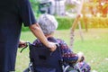 Asian senior or elderly old lady woman patient with care, help and support on wheelchair in park Royalty Free Stock Photo