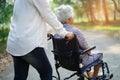 Asian senior or elderly old lady woman patient with care, help and support on wheelchair in park in holiday Royalty Free Stock Photo