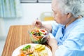 Asian senior or elderly old lady woman patient eating breakfast vegetable healthy food with hope and happy while sitting and