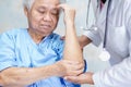 Asian senior or elderly old lady woman patient feel pain her elbow on bed in nursing hospital ward, healthy strong medical concept Royalty Free Stock Photo