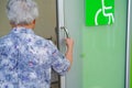 Asian senior elderly old lady woman patient open toilet bathroom by hand in nursing hospital ward