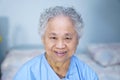 Asian senior or elderly old lady woman patient smile bright face while sitting on bed in nursing hospital ward Royalty Free Stock Photo
