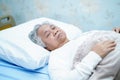 Asian senior or elderly old lady woman patient smile bright face with strong health while lying on bed in nursing hospital Royalty Free Stock Photo