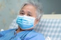 Asian senior or elderly old lady woman patient wearing a face mask to protect coronavirus and while sitting on bed in hospital. Royalty Free Stock Photo