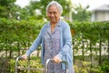 Asian senior or elderly old lady use walker with strong health while walking at park in happy holiday Royalty Free Stock Photo