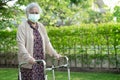 Asian senior or elderly old lady woman walk with walker and wearing a face mask for protect safety infection Covid-19 Coronavirus Royalty Free Stock Photo