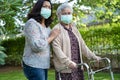 Asian senior or elderly old lady woman walk with walker and wearing a face mask for protect safety infection Covid-19 Coronavirus Royalty Free Stock Photo