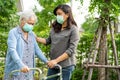 Asian senior or elderly old lady woman walk with walker and wearing a face mask for protect safety infection and kill Novel Royalty Free Stock Photo
