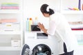 Asian senior elderly old woman housewife doing laundry at laundry room during looking at tablet, grandma using tablet in learning Royalty Free Stock Photo