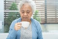 Asian senior or elderly old woman patient holding mug and drinking coffee in the morning at home,  healthy strong medical concept Royalty Free Stock Photo