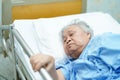 Asian senior or elderly old woman patient lie down handle the rail bed with hope on a bed. Royalty Free Stock Photo