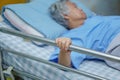 Asian senior or elderly old woman patient lie down handle the rail bed Royalty Free Stock Photo