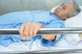 Asian senior or elderly old woman patient lie down handle the rail bed with hope in the hospital Royalty Free Stock Photo