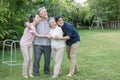 asian senior father trying walk with walker and adult son daughter wife support in gaden at home. old man disabled walking and Royalty Free Stock Photo