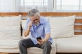 Asian senior fatigue man taking off glasses during using smartphone Royalty Free Stock Photo