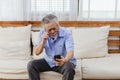 Asian senior fatigue man taking off glasses during using smartphone Royalty Free Stock Photo