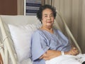 Asian senior  female patient  sitting  in hospital bed,  smiling and looking at camera. Elderly health concept Royalty Free Stock Photo