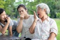Asian senior grandmother checking breath with her hand,elderly people bad breath,daughter,granddaughter closing her nose,very bad