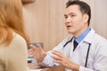 Asian Senior male Doctor talking to female patient. Royalty Free Stock Photo