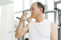 Asian senior man drinking water at a gym. Royalty Free Stock Photo