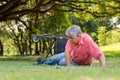 Asian senior man falling down from wheelchair on lying floor after trying push the wheelchair forward and Crying in pain and Royalty Free Stock Photo
