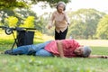 Asian senior man falling down from wheelchair on lying floor after trying push the wheelchair forward and Crying in pain and Royalty Free Stock Photo