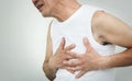 Asian senior man having heart attack while working out on white