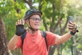 Asian Senior man making video call while travel with bicycle Royalty Free Stock Photo