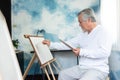 Asian Senior man painting on canvas on holiday Royalty Free Stock Photo