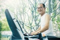 Asian senior man pushing the button and running on a treadmill Royalty Free Stock Photo