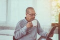 Asian senior man relaxing drinking coffee and using digital tablet at home in the morning Royalty Free Stock Photo