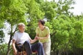 Asian senior man sitting on a wheelchair with his wife