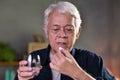Asian senior man taking pills at home Royalty Free Stock Photo