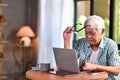 Asian senior man using laptop in living room at home Royalty Free Stock Photo