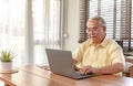 Asian Senior man using laptop and looking for Insurance after retirement. Grandfather stay alone Royalty Free Stock Photo