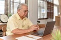 Asian Senior man using laptop and looking for Insurance after retirement. Grandfather stay alone Royalty Free Stock Photo