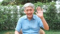 Asian senior older Chinese male using mobile phone video call talking with family grandchild kids. Royalty Free Stock Photo