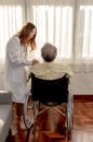 Asian Senior man was sick and sitting on wheelchair. The doctor check retirement age health Royalty Free Stock Photo