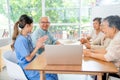 Asian senior man and woman enjoy to talk and fun with activity of nurse or doctor during teach with laptop on table in living room Royalty Free Stock Photo